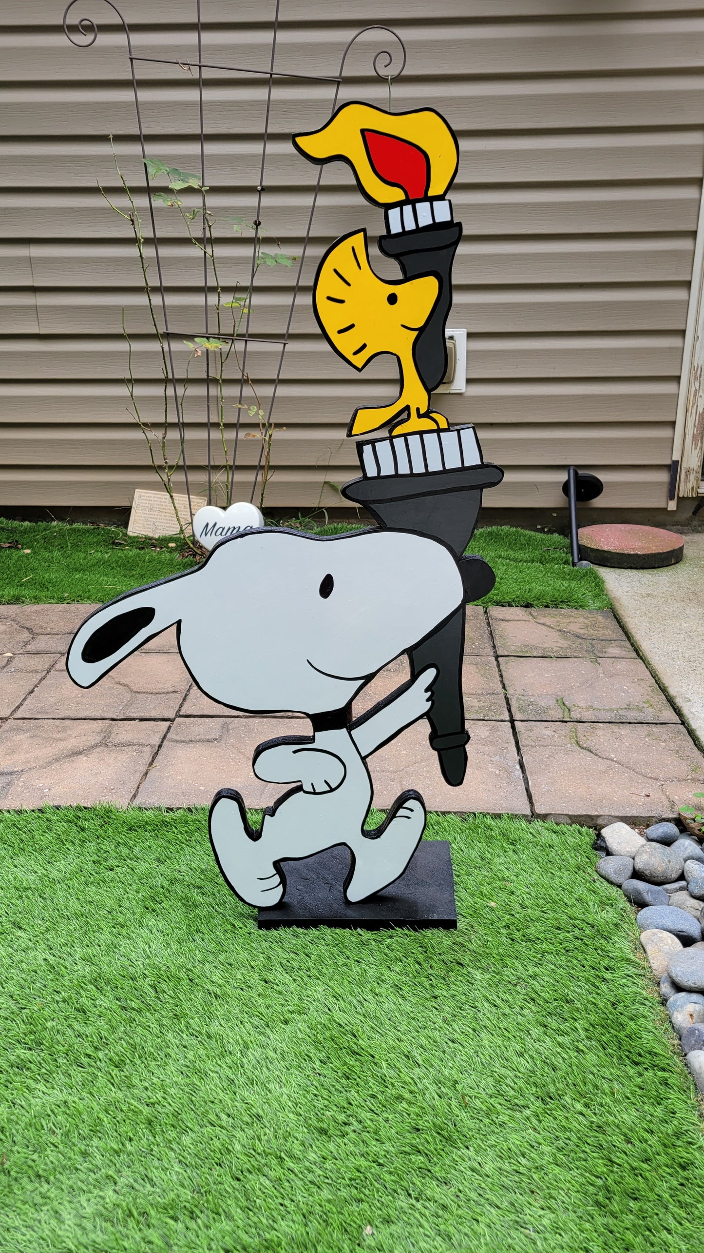 Snoopy carrying  Olympic torch. Yard art