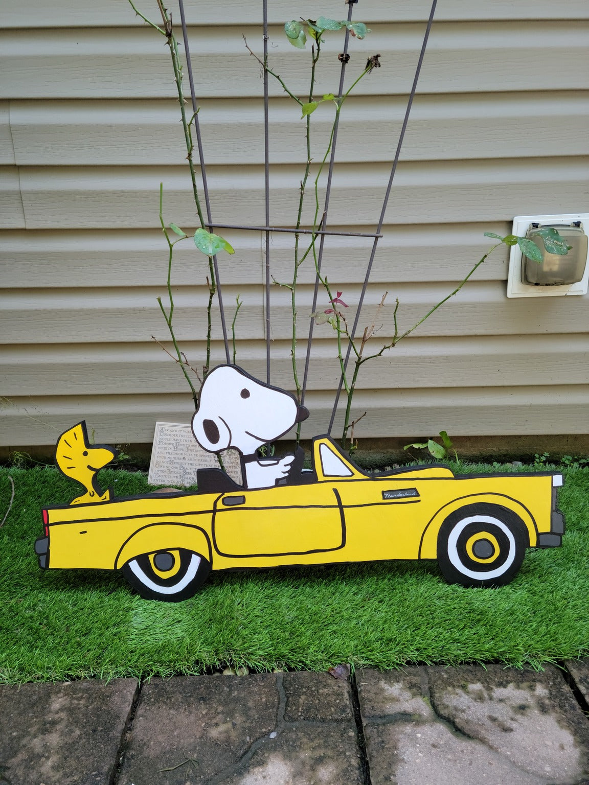 Snoopy driving 1955 thunderbird car. Yard art.