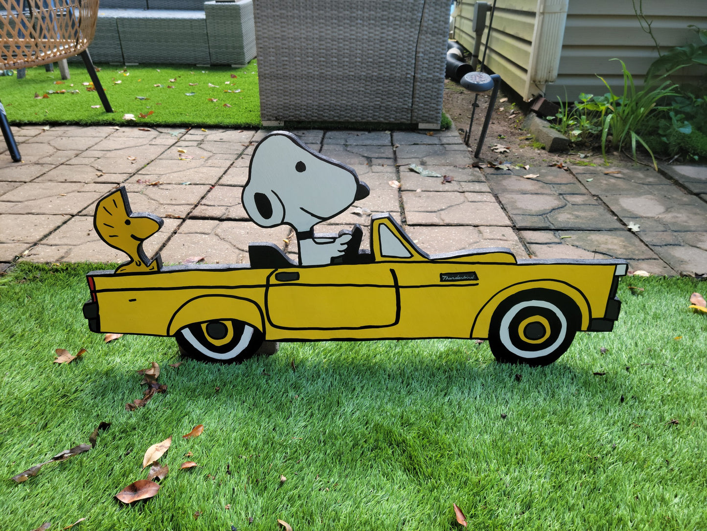 Snoopy driving 1955 thunderbird car. Yard art.