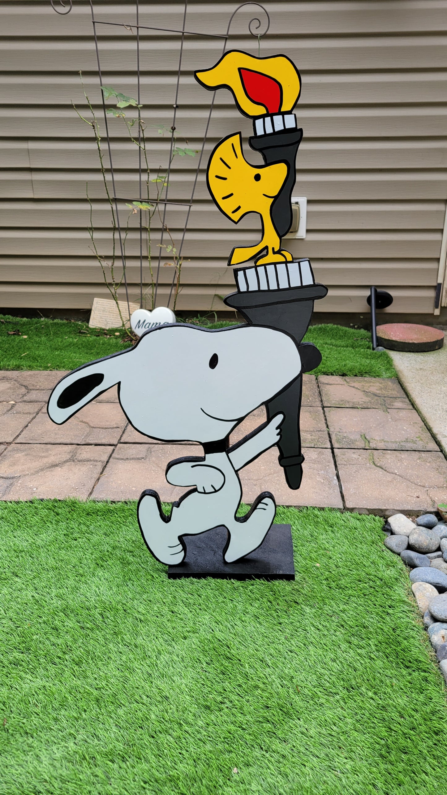 Snoopy carrying  Olympic torch. Yard art