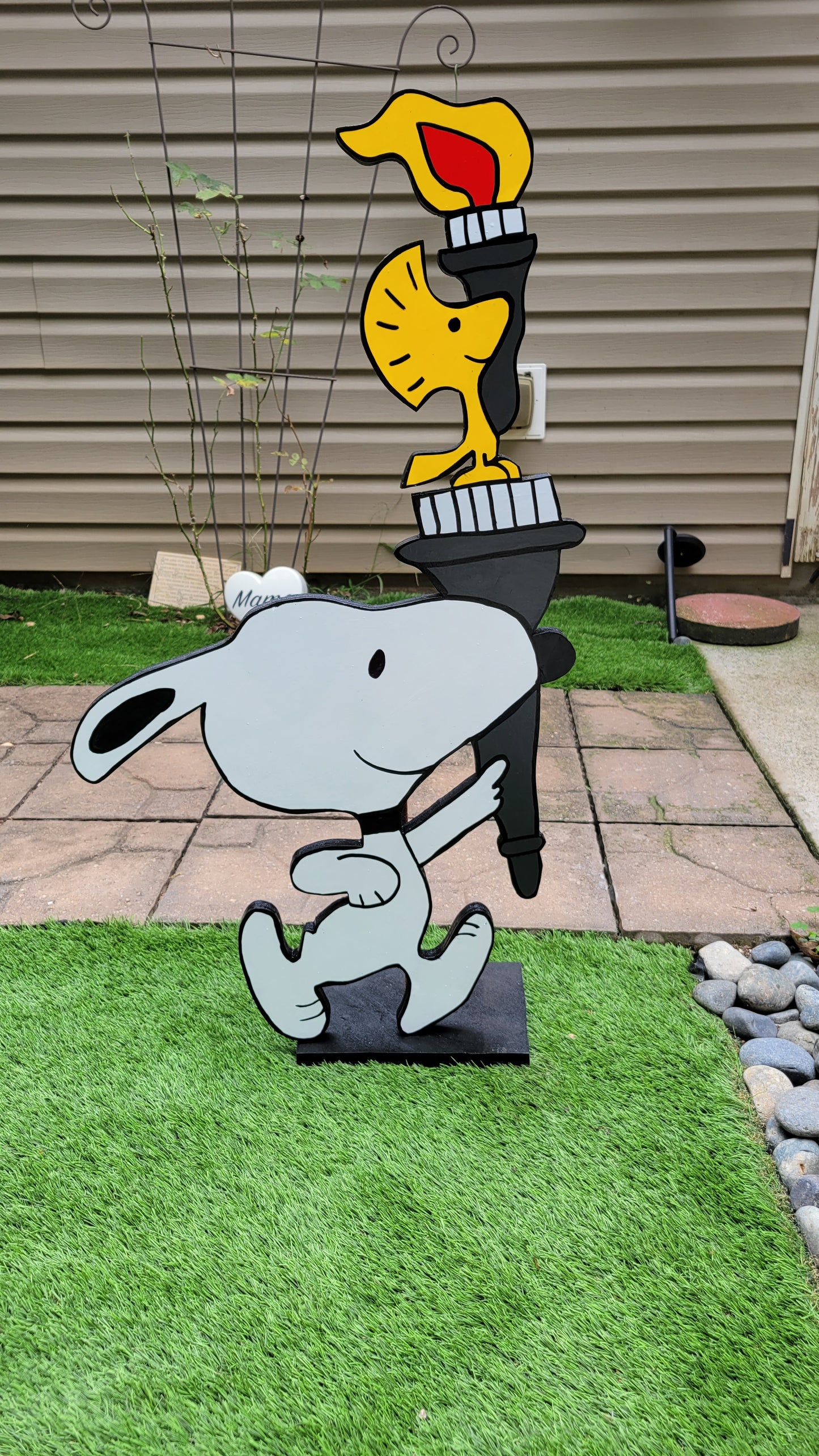 Snoopy carrying  Olympic torch. Yard art