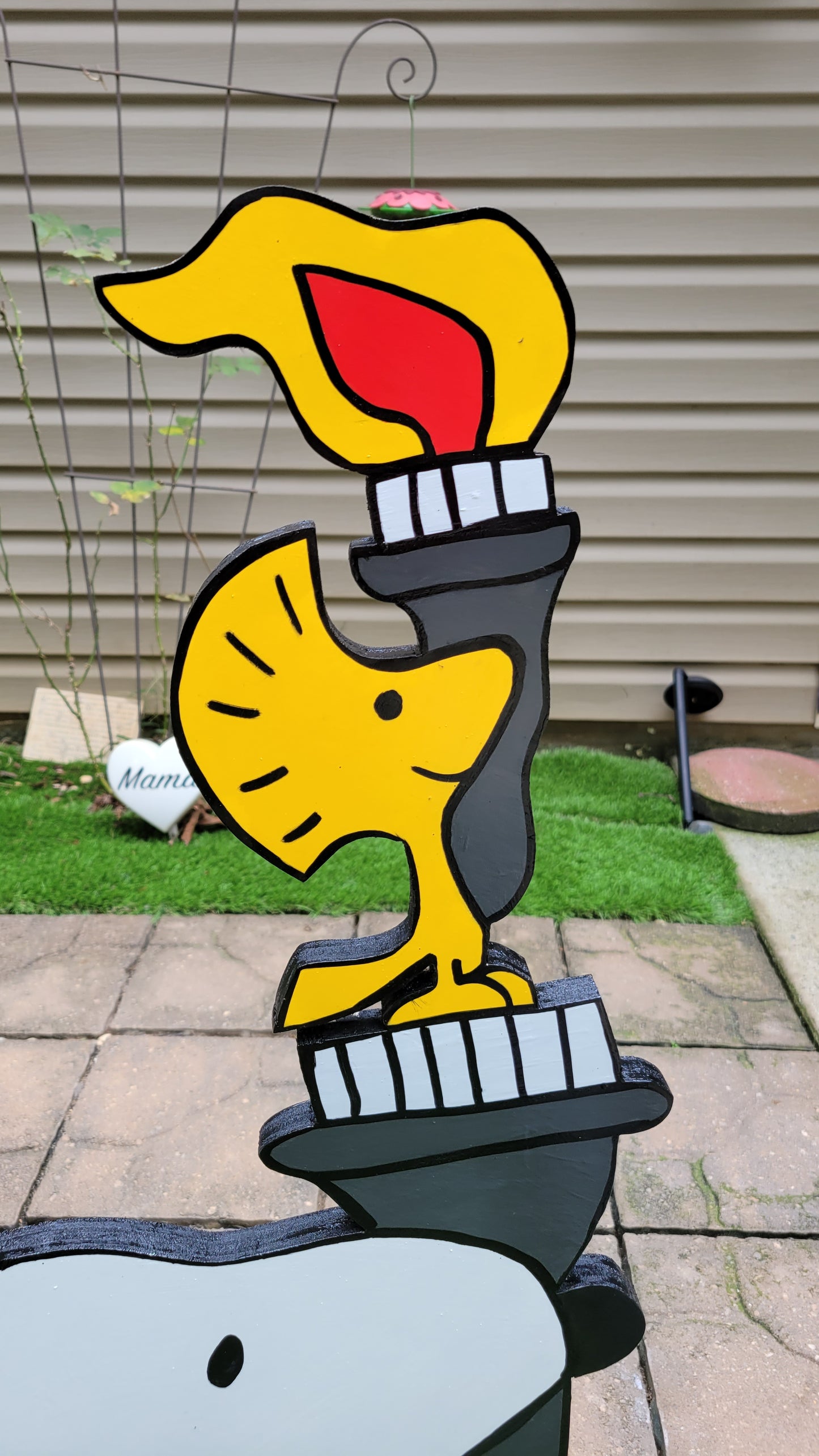 Snoopy carrying  Olympic torch. Yard art