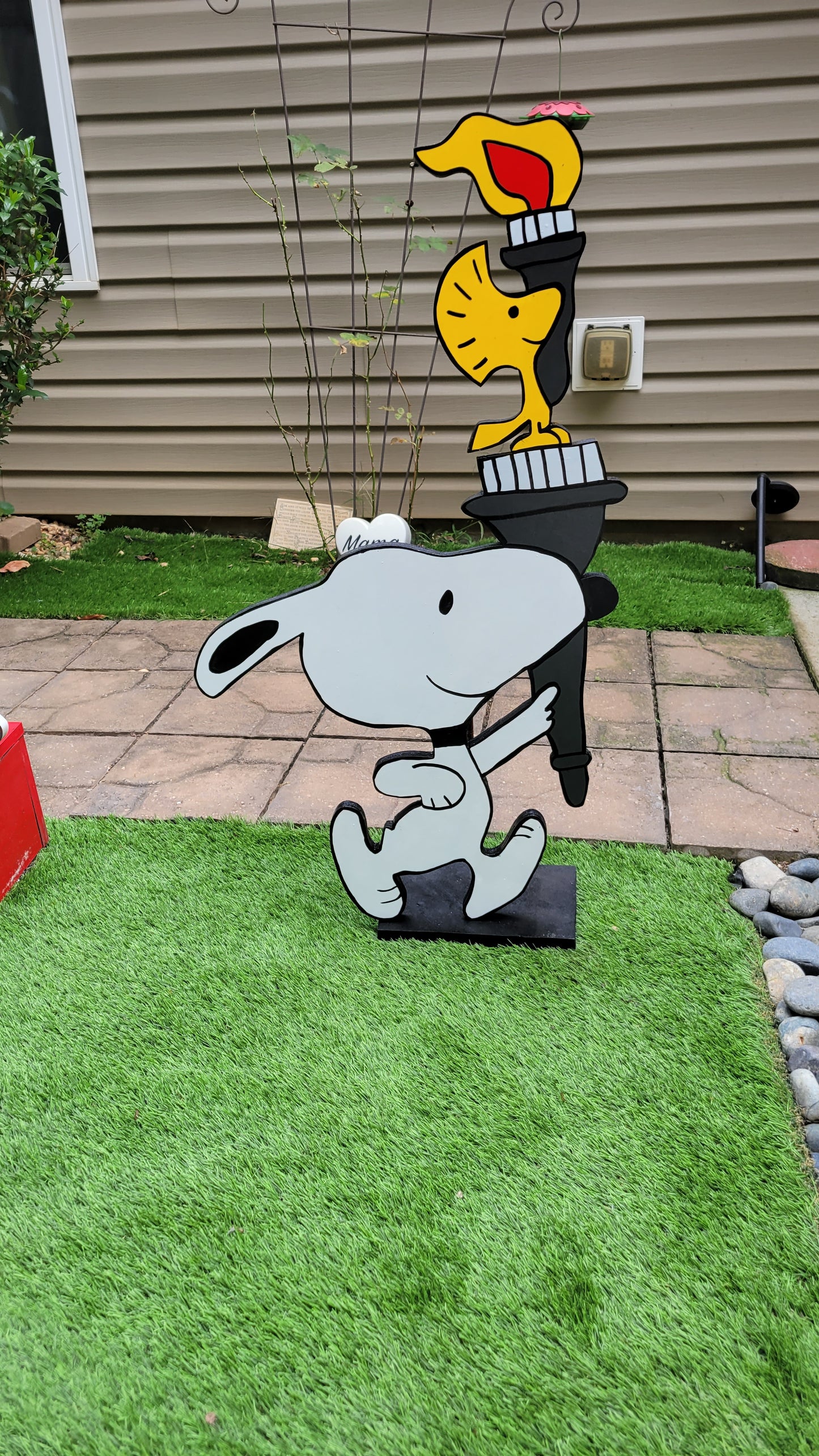 Snoopy carrying  Olympic torch. Yard art