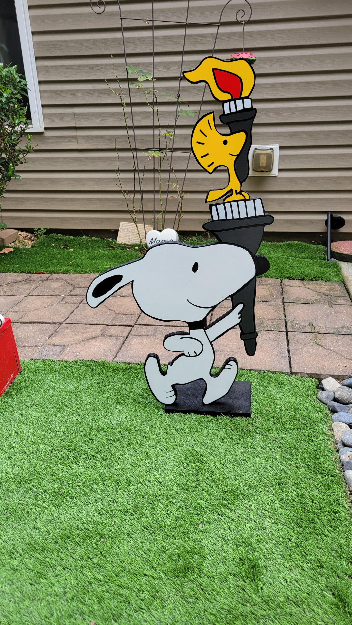 Snoopy carrying  Olympic torch. Yard art