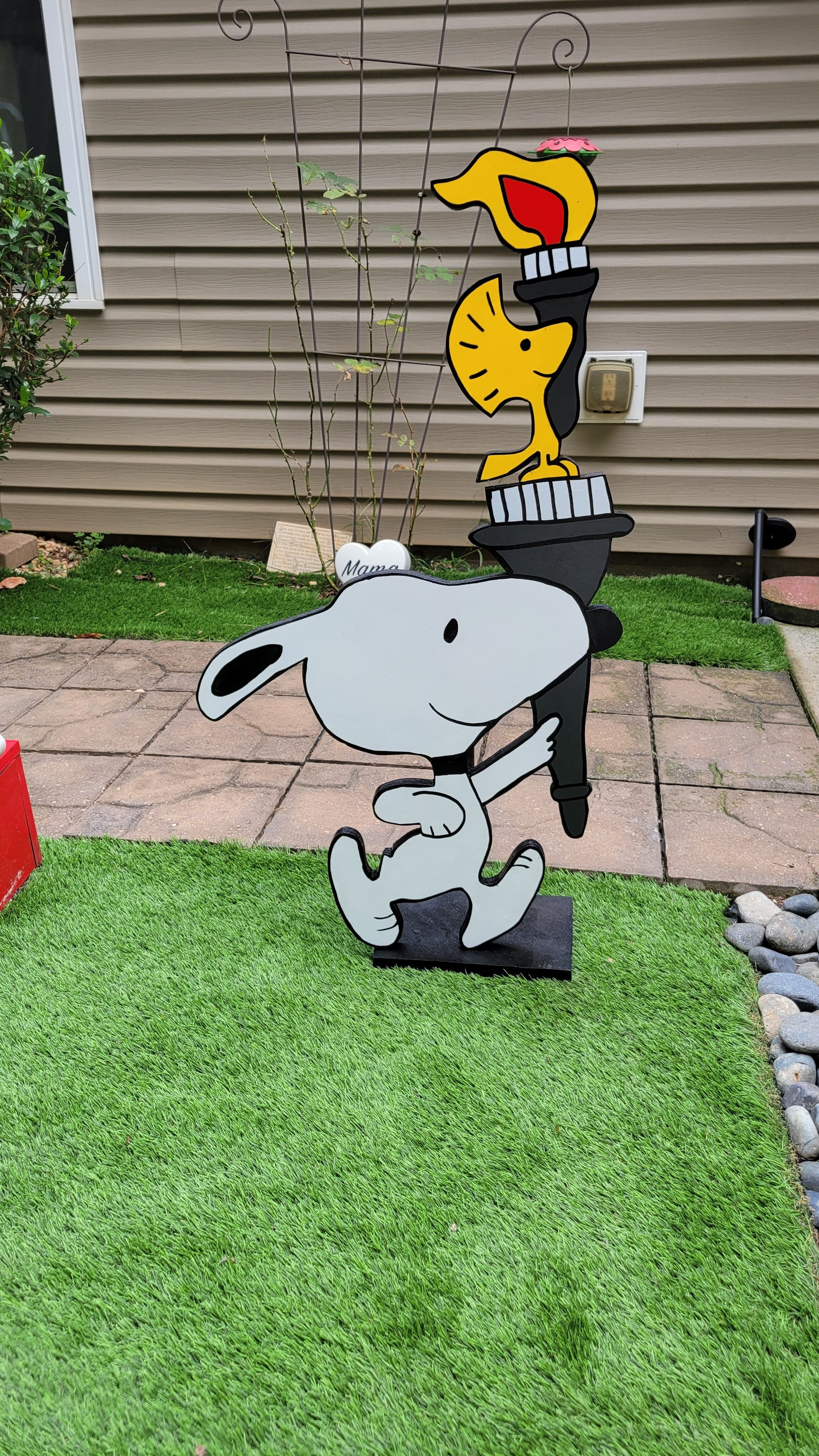 Snoopy carrying  Olympic torch. Yard art